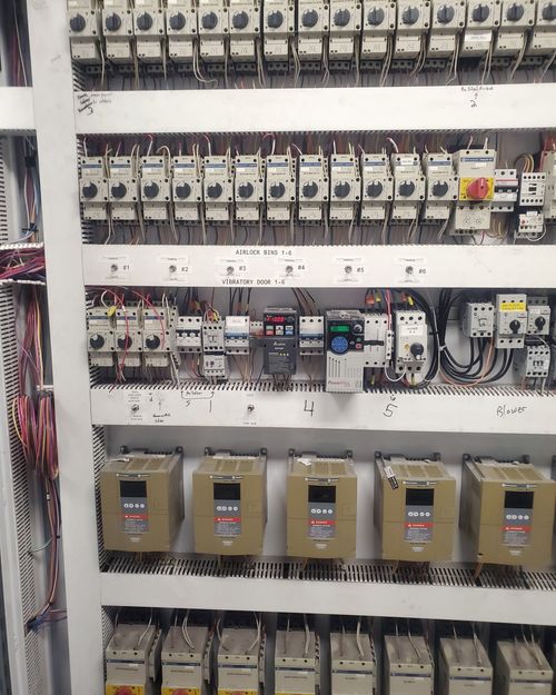 Custom motor control panel built in-house by McClone Electric for a grain elevator, showing labeled motor starters and color-coded wiring