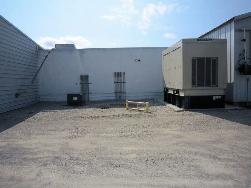Standby generator installed outdoors by McClone Electric, with feeder conduits run into the building